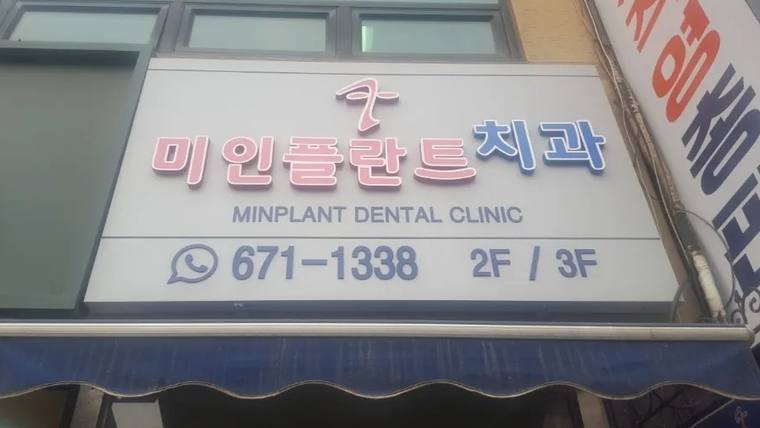 미인플란트치과라는 이름과 전화번호, 층수가 적힌 병원 간판을 촬영한 사진