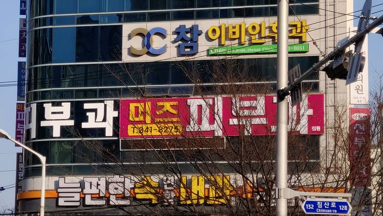 미즈피부과의원 — 건물 외벽에 여러 개의 한글과 숫자가 포함된 간판들이 부착되어 있는 모습이다.