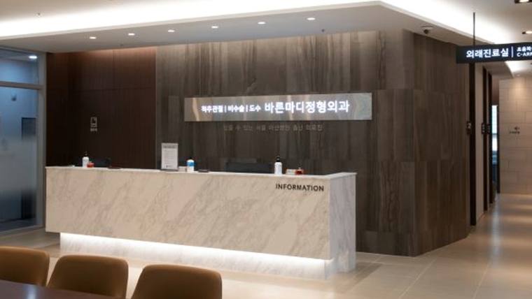 바른마디정형외과의원 — 대리석 느낌의 긴 데스크와 'INFORMATION' 문구가 적힌 안내 데스크가 있는 병원 로비의 모습
