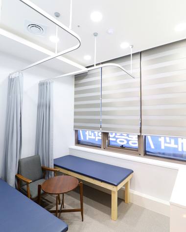백운탑신경과의원 — 병원의 대기실 공간에 긴 벤치와 창문이 있는 모습