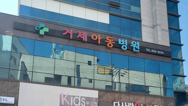건물 외벽에 '거제아동병원'이라는 문구와 전화번호가 적힌 간판이 설치되어 있다