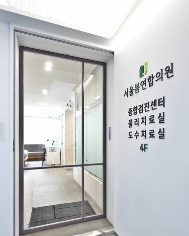 서울봄연합의원 — 병원 입구에 '서울여성병원'과 진료실 안내가 적힌 안내판과 유리문이 보입니다