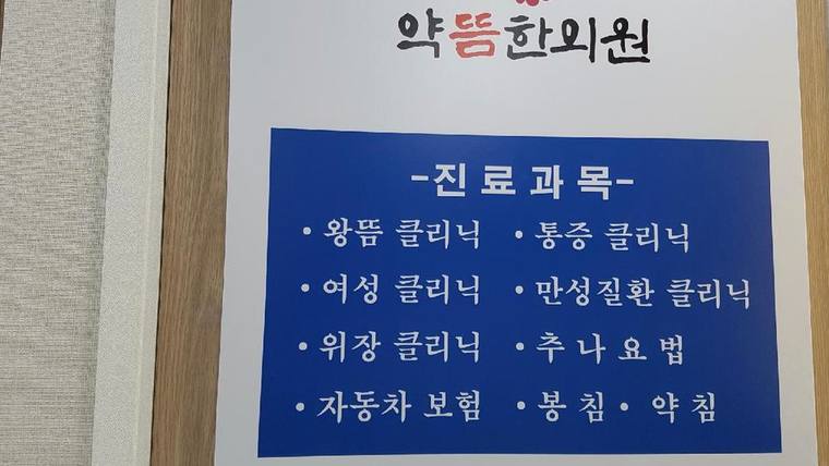 약뜸한의원 — 한의원의 진료 과목이 나열된 안내판이 벽에 부착되어 있다