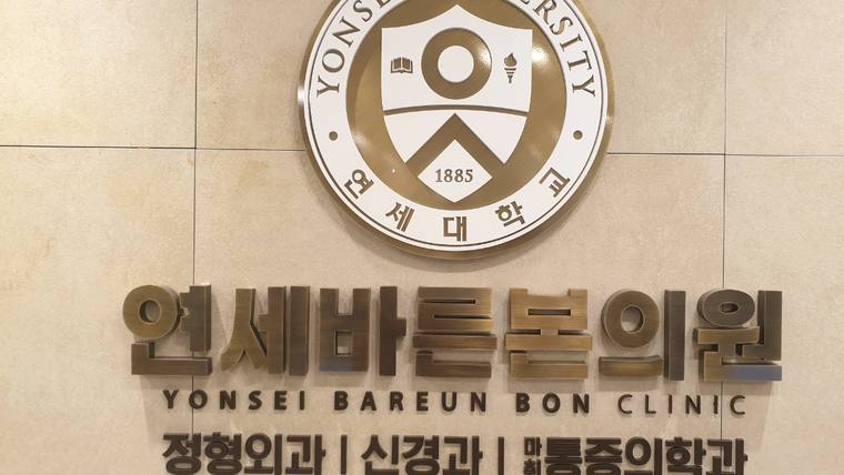 연세바른본의원 — 연세대학교 로고와 병원 이름이 적힌 간판이 벽면에 부착되어 있다