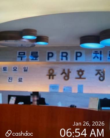 유상호정형외과의원 — 병원의 접수대 위로 '무료 PRP'라는 문구가 적힌 간판과 안내 문구가 적힌 벽면이 보입니다
