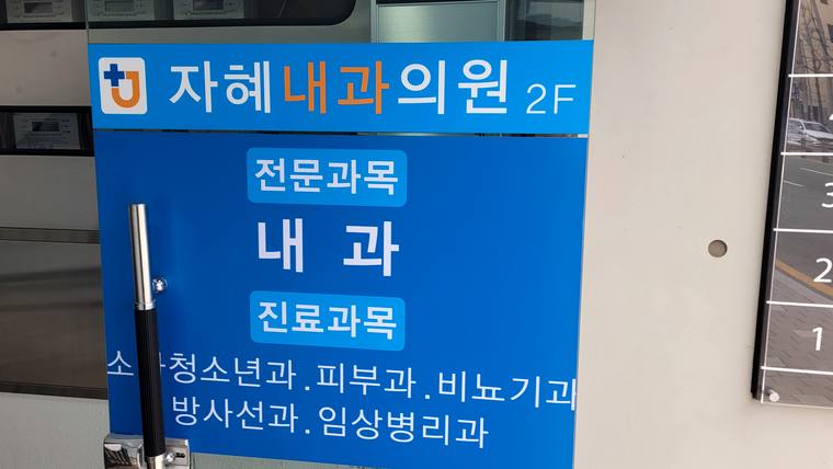 자혜내과의원 — 파란색 바탕에 흰색 글씨로 병원 이름과 진료 과목이 적힌 간판이 촬영된 사진