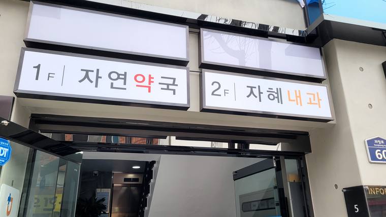자혜내과의원 — 건물 외벽에 1층 약국과 2층 내과가 표시된 두 개의 큰 간판이 나란히 설치되어 있다