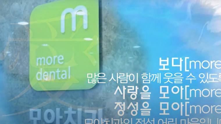 전주엠디치과의원 — 녹색 배경에 'more dental'이라는 문구와 한글 문구들이 적힌 홍보용 포스터나 광고판이 촬영된 사진