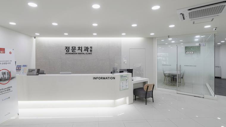 정문치과의원 — 흰색 벽면과 접수대가 있는 깔끔하고 현대적인 치과 병원 내부 로비의 모습