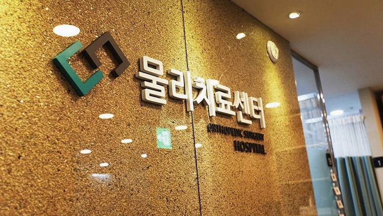 청라국제병원 — 황금색 질감의 벽면에 '물리치료센터'라는 한글 문구와 영어로 'PHYSIOTHERAPY SPECIAL INSTITUTE'라고 적힌 간판이 부착되어 있다