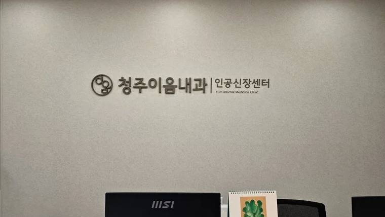 벽면에 '청주이올내과 | 인공신장센터'라는 문구와 로고가 새겨져 있는 실내 벽면 사진